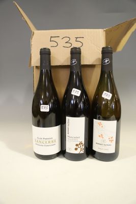 three bottles of wine are in a cardboard box on a table