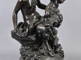 a bronze statue of a woman sitting on a rock with a dog
