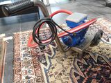 une machine à nettoyer les moquettes posée sur un tapis dans une pièce
