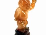 a small figurine of a baby sitting on top of a rock