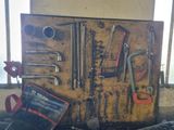 a lot of tools hanging on the wall next to a keyboard