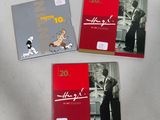 three books with pictures of people and dogs on them sitting on a table