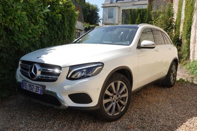 La Mercedes GLC est garée devant une maison