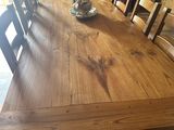 une table en bois avec des chaises et un vase posé dessus