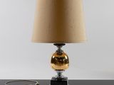 a lamp that is sitting on a table with a lamp shade on it