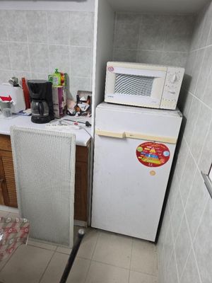 a small kitchen with a refrigerator and a microwave in it