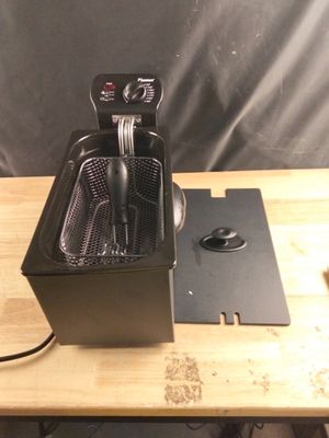 une photo d'une friteuse posée sur une table en bois