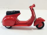 une trottinette rouge posée sur une surface blanche