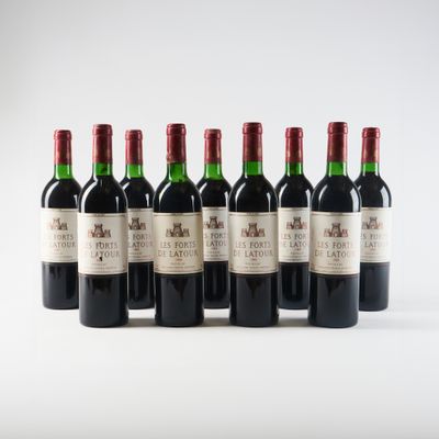 six bouteilles de vin rouge alignées sur une surface blanche