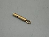 a small metal object on a white surface with a small metal object in the background