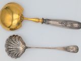 two spoons and a ladle on a white surface