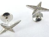 paire de boucles d'oreilles en forme d'étoiles de mer en argent, ornées de diamants sur fond blanc
