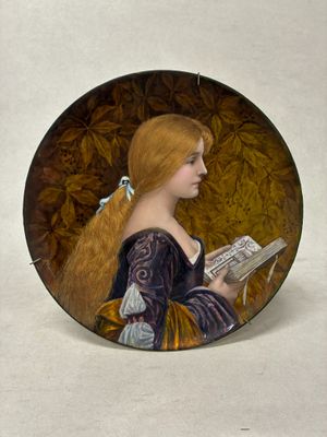 une assiette sur laquelle est représentée une femme en train de lire un livre