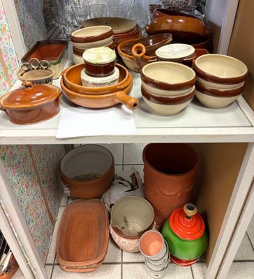 de nombreux bols et casseroles sur une étagère dans la cuisine
