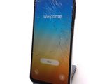 an image of a cell phone with a broken screen sitting on a stand