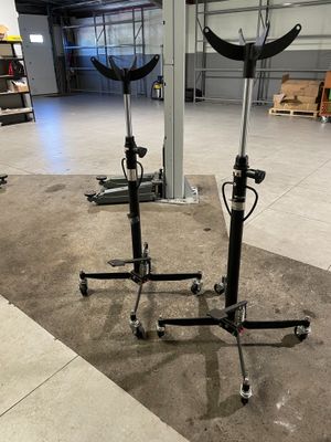 deux supports noirs équipés de roulettes, dans un entrepôt