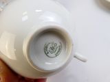 a person holding a white cup on a table