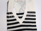 Le pull est noir et blanc, avec des rayures.