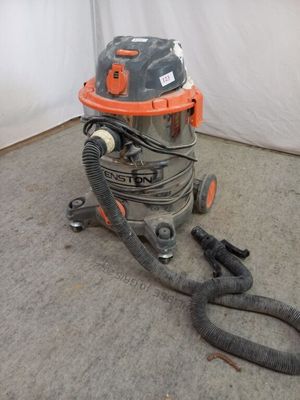 une machine à laver et sèche-linge orange et grise posée à même le sol