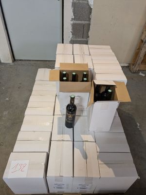 a pile of boxes and a bottle of wine on a table