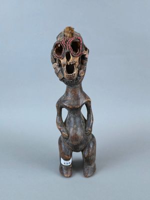 figurine représentant une femme avec un crâne sur la tête