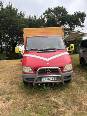 une camionnette rouge garée dans l'herbe