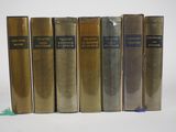 six livres sont alignés sur une surface blanche