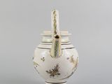 a white vase with a handle and a lid