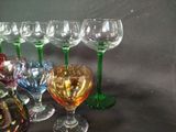 many different colored wine glasses lined up on a table