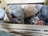 une caisse en bois remplie de cailloux et une canette de soda