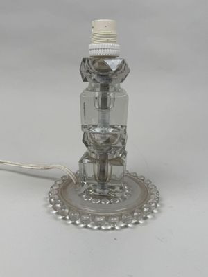 silver plated table lamp with a glass shade on top of it