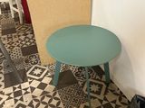a small table with a green top in a room