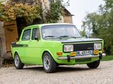 une petite voiture verte garée devant une maison