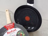 two frying pans sitting on a counter top