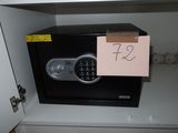 a safe box with a key on it in a cabinet