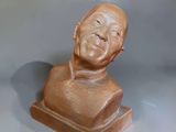 a small statue of a man with a smile on it ' s face
