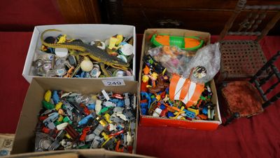 two boxes of assorted legos on a bed