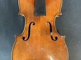 un vieux violon posé sur une table près d'un mur