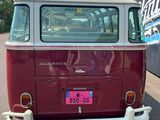 un minibus Volkswagen rouge et blanc garé sur un parking