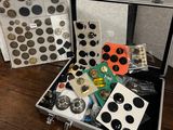 deux valises contenant des boutons, posées sur une table