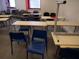 des tables et des chaises dans une pièce avec une fenêtre rouge et une chaise bleue