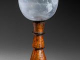 une image représentant un vase en verre posé sur un socle en bois