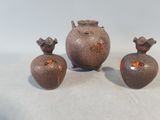 trois vases posés l'un à côté de l'autre sur une table