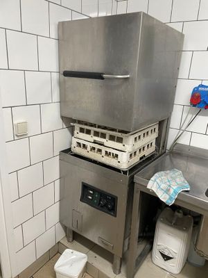 une cuisine équipée d'une cuisinière, d'un évier et d'une poubelle