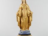 a gold statue of the virgin of guadalupe on a pedestal