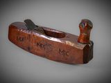 an old wooden plane with a wooden handle sitting on top of a table