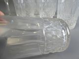une personne en train de verser de l'eau dans un verre à l'aide d'une paille