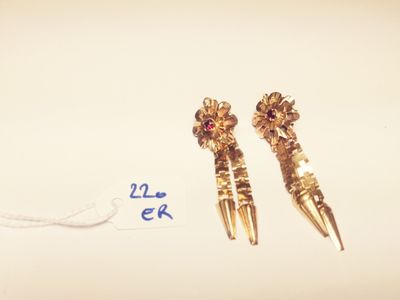 two pairs of gold earrings with red stones on them