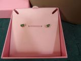 pair of green crystal stud earrings in a pink box