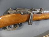 an old gun with a wooden handle on display in a glass case